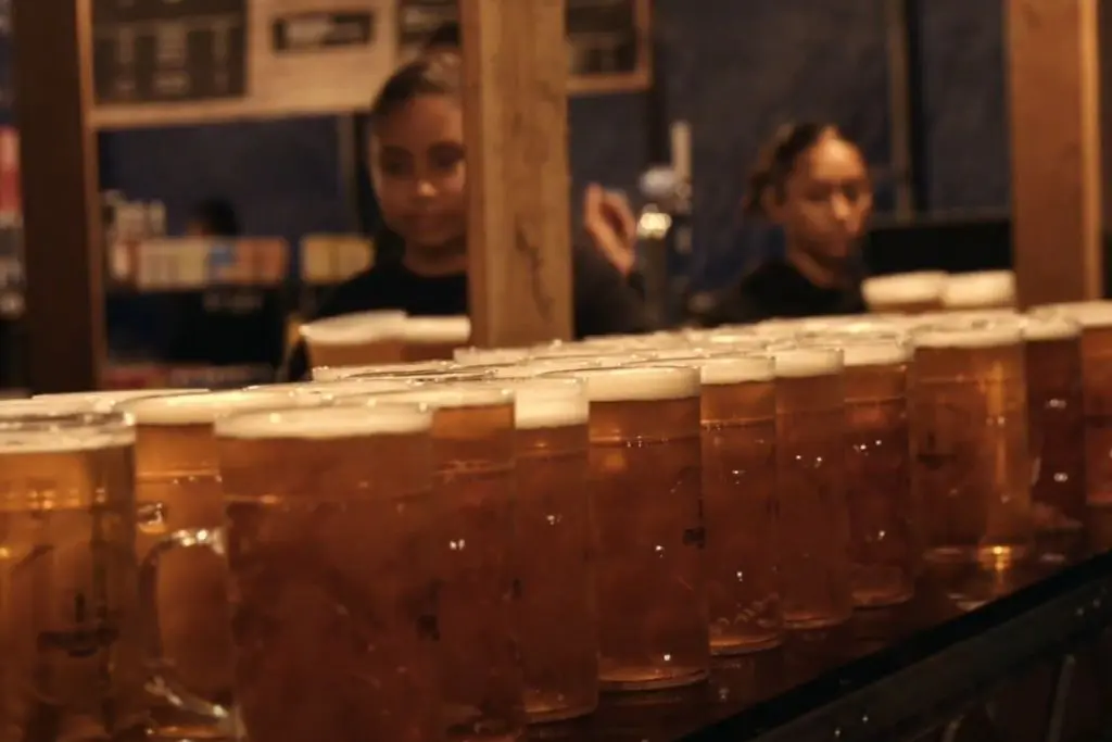 Servers piling tons of beer mugs on countertop